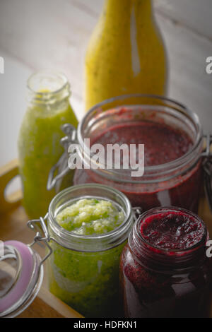 Gläser mit verschiedenen Smoothies in der Holzkiste Stockfoto