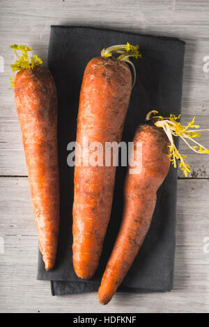 Rohe Karotten auf dem weißen hölzernen Hintergrund vertikale Stockfoto