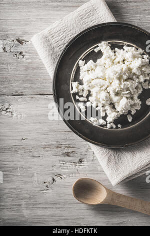 Frische Quark auf der Metallplatte auf dem vertikalen weißen Holztisch Stockfoto