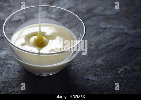 Kondensmilch in der horizontalen Glasschüssel gießen Stockfoto