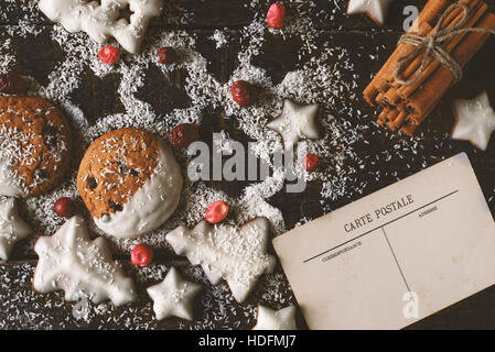 Weihnachtsplätzchen mit Postkarte und Zimt auf den hölzernen Hintergrund Stockfoto