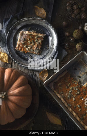 Scheibe Kürbiskuchen auf der Metallplatte auf dem Holztisch mit Herbst Geschenke Stockfoto