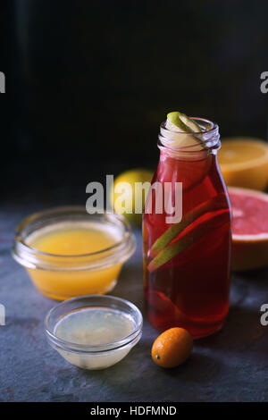 Glasflasche mit citrus Cocktail auf dem dunklen Stein Hintergrund Stockfoto
