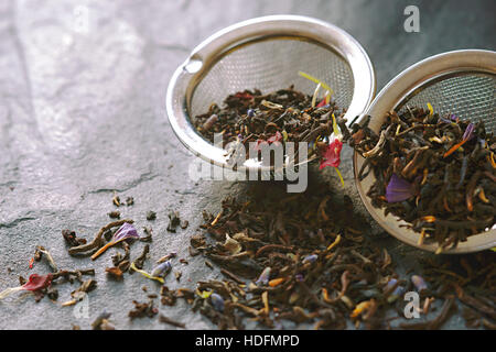 Tee mit Blume Blütenblatt in das Sieb auf dem Stein Hintergrund horizontale Stockfoto
