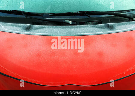 Raureif bedeckt, Windschutzscheibe und vordere Motorhaube rote Autos Stockfoto