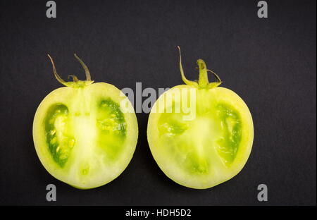 In Scheiben geschnittenen rohe grünen Tomaten auf dunklen backgeround Stockfoto