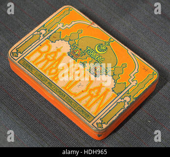 Ein Bild eines alten Ramadan sigaretten blik (Zigarettendose), wahrscheinlich aus dem frühen bis Mitte des 20. Jahrhunderts. Die Dose verfügt über komplizierte Designarbeiten, die möglicherweise kulturelle Elemente der Zeit widerspiegeln, sowie das unverwechselbare Logo und die Farben der Marke. Stockfoto