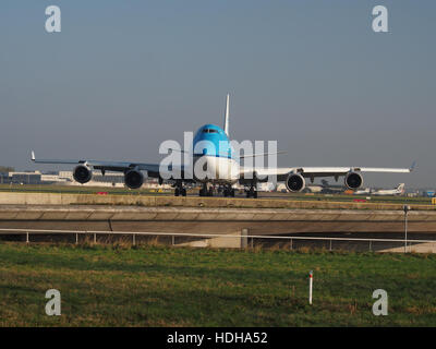 Dieses Bild zeigt eine KLM Royal Dutch Airlines Boeing 747-406, die auf die Start- und Landebahn 36L am Flughafen Schiphol fährt und die große Größe des Flugzeugs und die geschäftige Atmosphäre eines internationalen Flughafens zeigt. Stockfoto