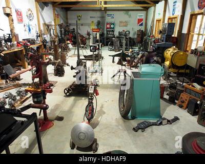 Ein historisches Foto aus einer Ford-Werkstatt, das Arbeiter zeigt, die Ford-Fahrzeuge montieren. Dieses Bild zeigt die industriellen Prozesse und die Arbeitskräfte hinter den frühen Produktionstechniken von Ford und unterstreicht den Umfang und die Effizienz der Automobilherstellung während des frühen 20. Jahrhunderts. Stockfoto