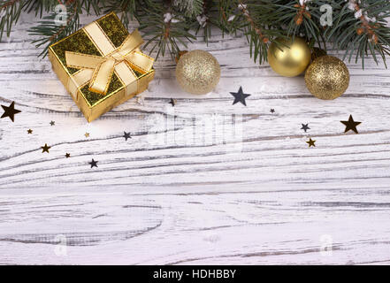 Weihnachts-Dekoration mit Weihnachten silberne und goldene Kugeln Sterne Schneeflocken natürliche Tannenzweigen und Zapfen auf weißem Holz Hintergrund Stockfoto