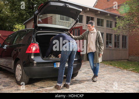 Frau Mann Verpackung Gepäck im Kofferraum beobachten Stockfoto