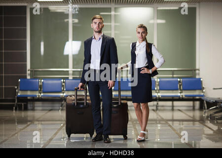 In voller Länge Portrait von junge Unternehmer und Unternehmerin mit Gepäck im Flughafen Stockfoto