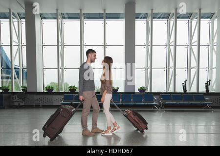 Voller Länge Seitenansicht des jungen Paares mit Gepäck sahen einander am Flughafen Stockfoto