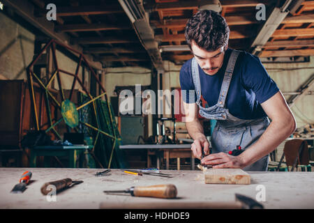 Tischler mit Meißel auf Holzbrett in Werkstatt Stockfoto