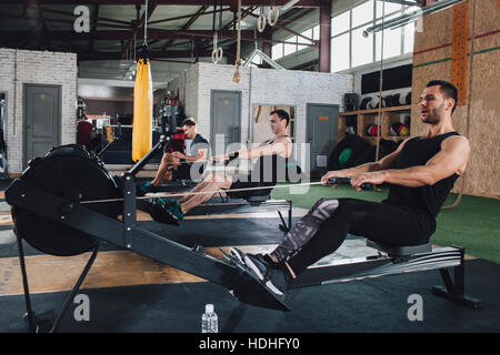 Bestimmt Männer trainieren am Rudergerät im Health club Stockfoto