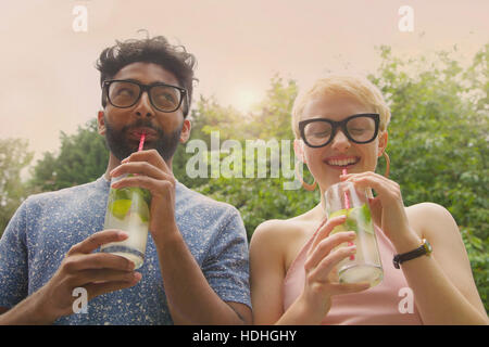 Niedrigen Winkel Blick auf fröhliche paar trinken Limonade am Hof Stockfoto