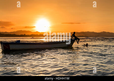 Silhouette eines Bootes und Menschen an einem Strand in Puerto Viejo de Talamanca, Costa Rica, Mittelamerika Stockfoto