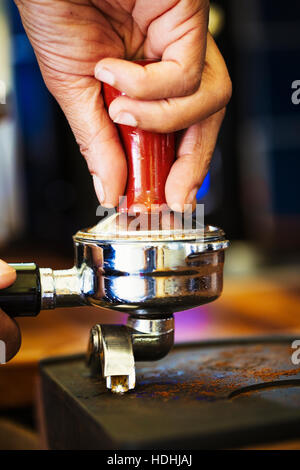 Nahaufnahme der menschlichen Hand, die Siebträger Espressomaschine. Stockfoto