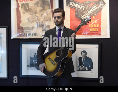 Ein Mitarbeiter hält eine Gitarre, die einst im Besitz von Jimi Hendrix auf dem Display an der Unterhaltung Erinnerungsstücke Verkauf bei Bonhams Knightsbridge, London. Stockfoto