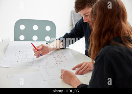 Ein modernes Büro. Zwei Menschen bei einem Treffen, diskutieren, Pläne und Zeichnungen, Architekturzeichnungen. Stockfoto