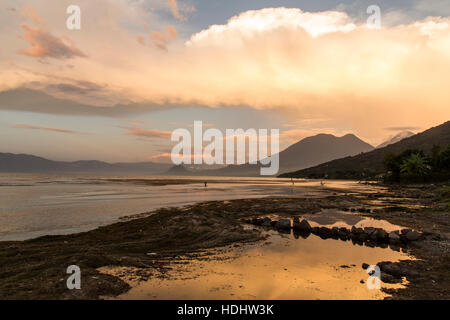 Bunte Wolken über Lake Atitlan, Guatemala bei Sonnenuntergang.  Neigung der inaktiven San Pedro Volcano auf rechten Seite, mit doppelter Spitze des Atitlan Vulkan dahinter ein Stockfoto