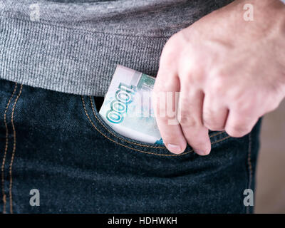 Hand legen Rubel in Jeans-Tasche Stockfoto