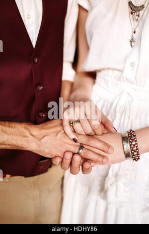 Männliche und weibliche Hand in Hand. Hände mit Boho chic Zubehör Nahaufnahme. Stockfoto