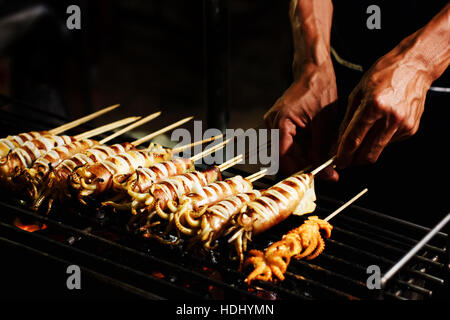 Suppen im Freien im asiatischen Land, gegrillte Bbq Tintenfische auf Sticks vorbereiten Stockfoto