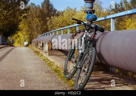 Fahrrad stützte sich auf ein Rohr Stockfoto