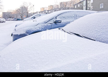 Schnee und Eis bedeckt auf parkende Autos außerhalb in Schweden im Dezember. Stockfoto