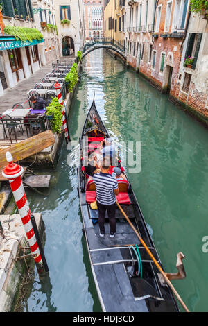 Gondel mit Touristen in den Kanälen von Venedig. Stockfoto