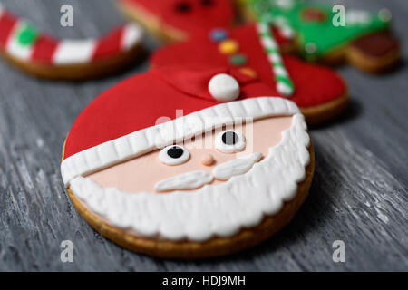 Nahaufnahme von einem Sortiment von Weihnachtsplätzchen mit verschiedenen Formen und Farben auf einer rustikalen Holzoberfläche Stockfoto