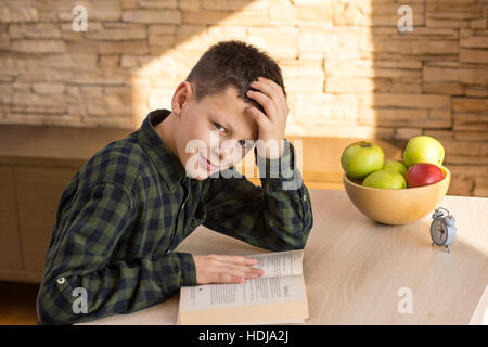 Kleiner Junge Lesebuch und Studium am Schreibtisch zu Hause Stockfoto