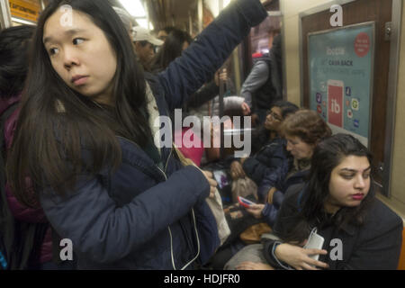 Eine gepackte R u-Bahn voller Arbeiter und Studenten in Brooklyn, New York in den Feierabendverkehr. Stockfoto