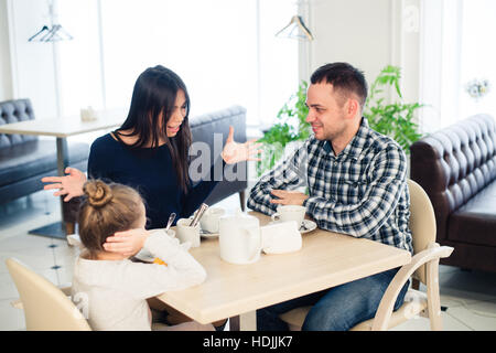 Paar kämpft vor Kind im Café oder im Restaurant. Stockfoto