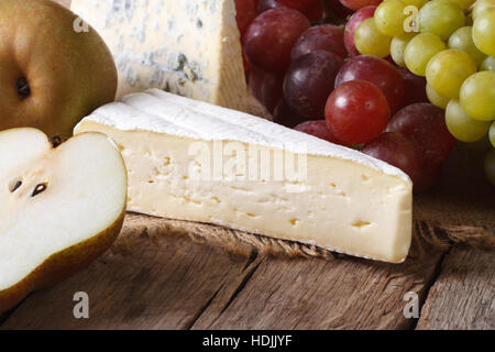 Geformte Käse, Trauben und Birnen close-up auf dem Tisch. horizontale rustikalen Stil Stockfoto