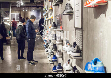 Kunden drängen sich den neuen Adidas Flagshipstore auf der Fifth Avenue in New York auf Sonntag, 11. Dezember 2016. Bei 45.000 qm ist der Shop Adidas größten. Nike, der weltweit größte Hersteller von sportlichen Ausrüstung und Bekleidung verliert an Boden als Wettbewerber Adidas und Upstart Under Armour weiter Marktanteile zu gewinnen. (© Richard B. Levine) Stockfoto