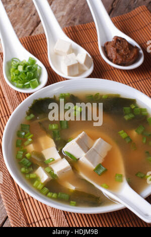 Japanische Miso-Suppe in eine weiße Schüssel mit einem Löffel auf eine Tabelle Nahaufnahme. horizontale Stockfoto