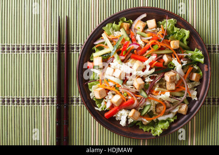 Asiatischer Salat mit Tofu und frischem Gemüse auf einem Teller hautnah. horizontale Ansicht von oben Stockfoto