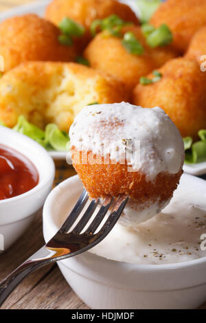 Kartoffel Kugeln Kroketten mit Sauerrahm-Makro. vertikale Stockfoto