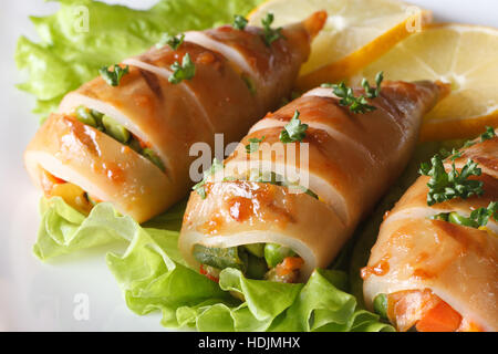 Gebratener Tintenfisch mit Gemüse Closeup auf Salatblätter auf einen Teller gefüllt. horizontale Stockfoto