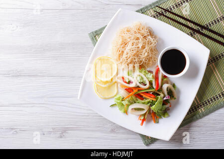 Reis, Nudeln und Gemüse-Salat mit Tintenfisch auf einem Teller. horizontale Ansicht von oben Stockfoto