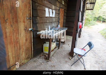 rustikale Holz Campingplatz Sanitärgebäude mit externen Waschbecken Stockfoto