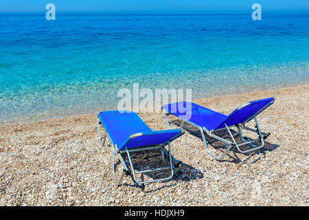 Sommer morgen kiesiger Strand mit Sonnenliegen (Albanien). Stockfoto