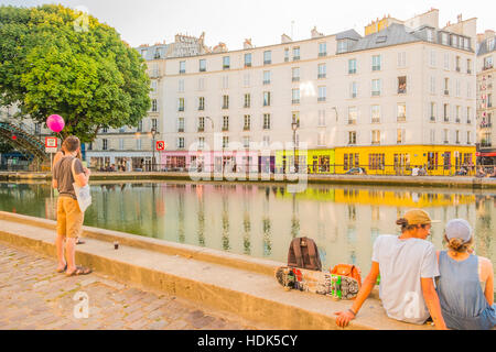 Menschen entspannen am Canal Saint-Martin bei Dämmerung, Quai de Jemmapes Blick auf Quai de Valmy, Paris, Ile de France, Farnce Stockfoto