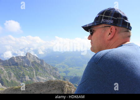 Ein amerikanischer Tourist genießt die schöne Aussicht vom Gipfel des Säntis in den Schweizer Alpen. Stockfoto