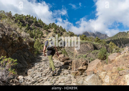 Eindrucksvolle Schlucht der Angst "Barranco de Las Angustias" in La Palma Kanarische Inseln. Eine Frau klettert auf einen steilen, steinigen Weg. Stockfoto