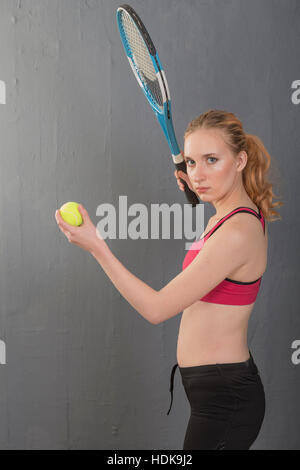 Ein attraktives Mädchen mit einem Tennisschläger. Stockfoto