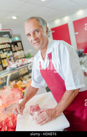 Metzger, die Vorbereitung einer Fuge von Rindfleisch in seinem Geschäft Stockfoto