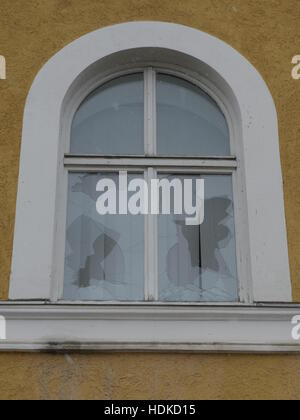 Löcher in der ausgetretenen Fensterscheibe Stockfoto